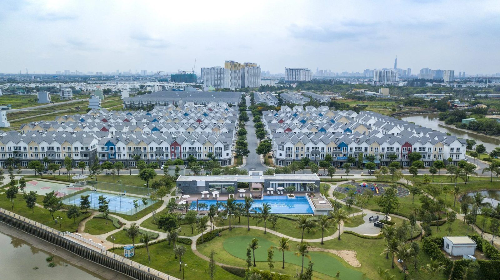 Ảnh flycam thực tế khu nhà phố Park Riverside của MIK Group ở khu Đông TP.HCM: dãy nhà liền kề, hồ bơi và công viên ven sông