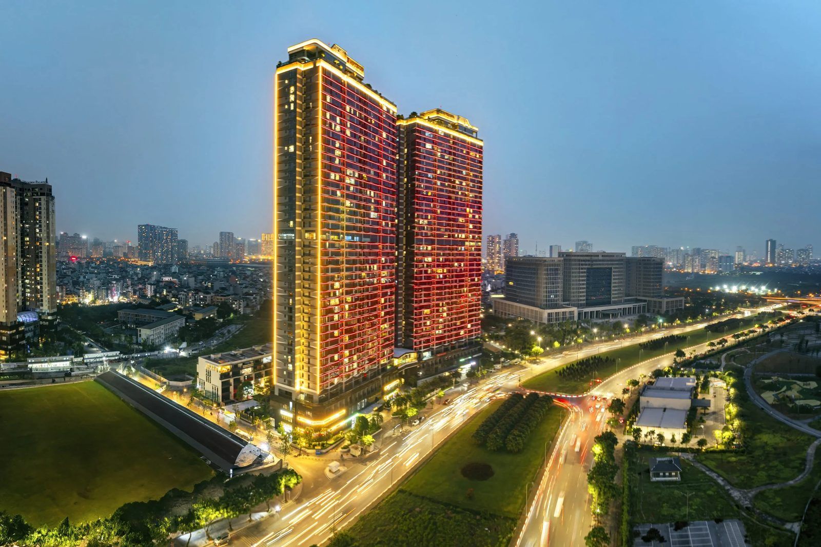 Ảnh thực tế The Matrix One của MIK Group ở Mễ Trì, Hà Nội về đêm: hai tháp căn hộ thắp đèn cạnh đại lộ