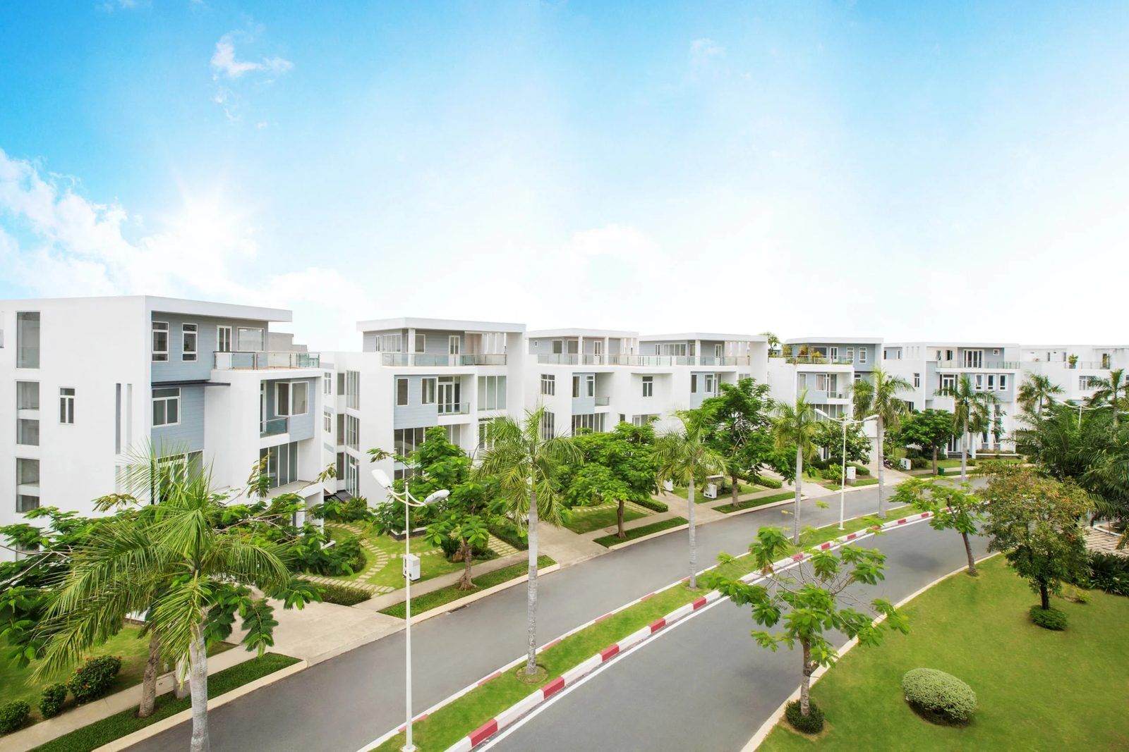 Ảnh thực tế dãy biệt thự Villa Park của MIK Group đã bàn giao, nhà ba tầng sơn trắng dọc đường nội khu có cây xanh