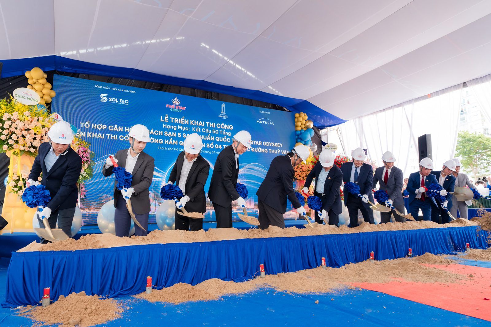 Đại diện chủ đầu tư và tổng thầu xúc cát tại nghi thức triển khai thi công kết cấu phần thân Five Star Odyssey, tháng 7/2026
