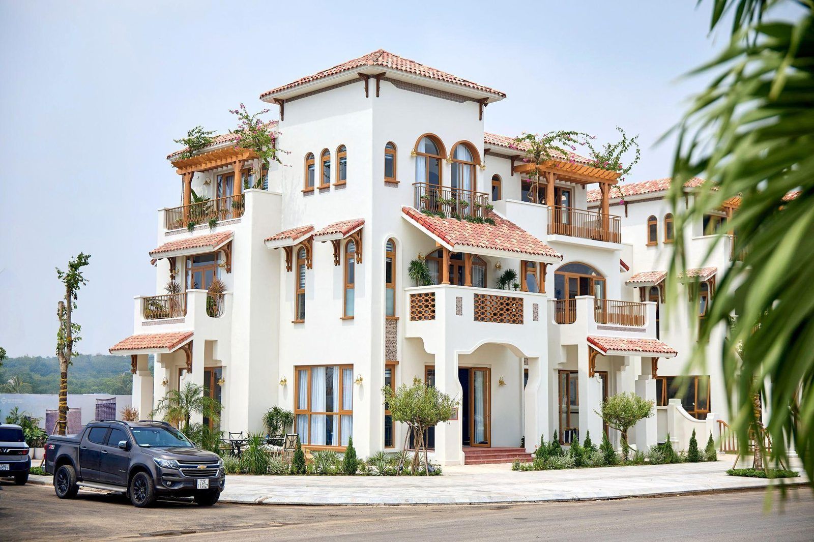 Biệt thự Casa Villa tại Blanca City đã xong mặt ngoài: ba tầng nổi, mái ngói, ban công vòm kiểu Địa Trung Hải, hàng cây non phía trước