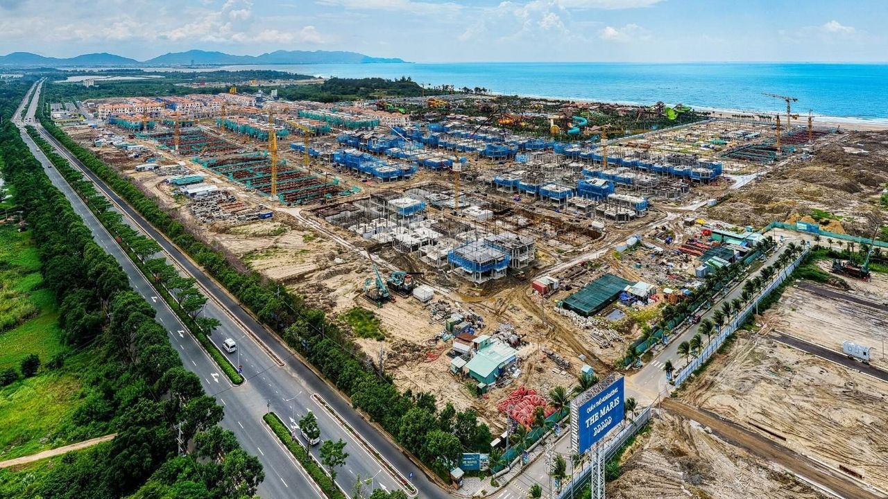 Ảnh trên cao công trường phần cao tầng Blanca City tháng 9/2026: hố móng và cần cẩu tháp cạnh đường 3 Tháng 2, biển ở phía xa