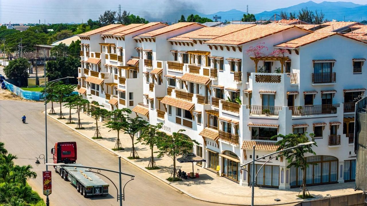 Dãy nhà phố Casa Townhouse tại Blanca City đã hoàn thiện mặt ngoài: tường trắng, ban công, mái ngói đất nung, đường nội khu đã thảm nhựa