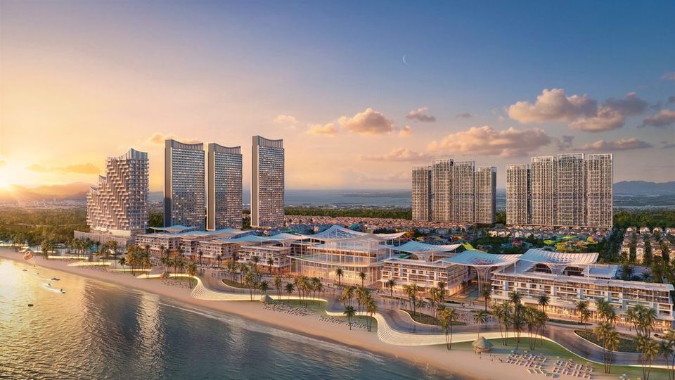 Phối cảnh trung tâm thương mại mặt biển Blanca City: khối nhà thấp tầng mái cong chạy dọc bãi cát, các tháp căn hộ phía sau lúc hoàng hôn